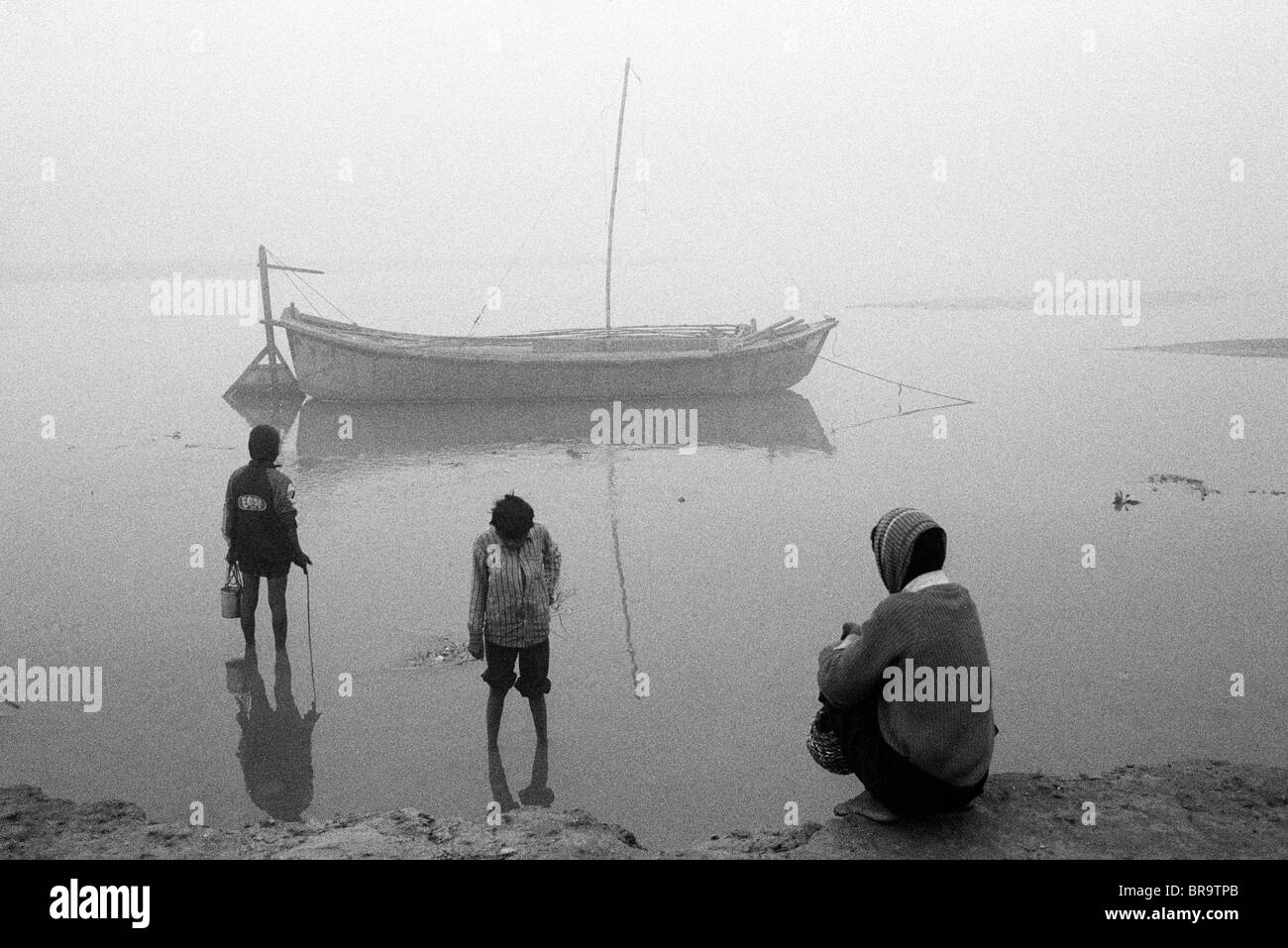 Drei Jungs bank am frühen Morgen am Ganges Allahabad Indien. Stockfoto
