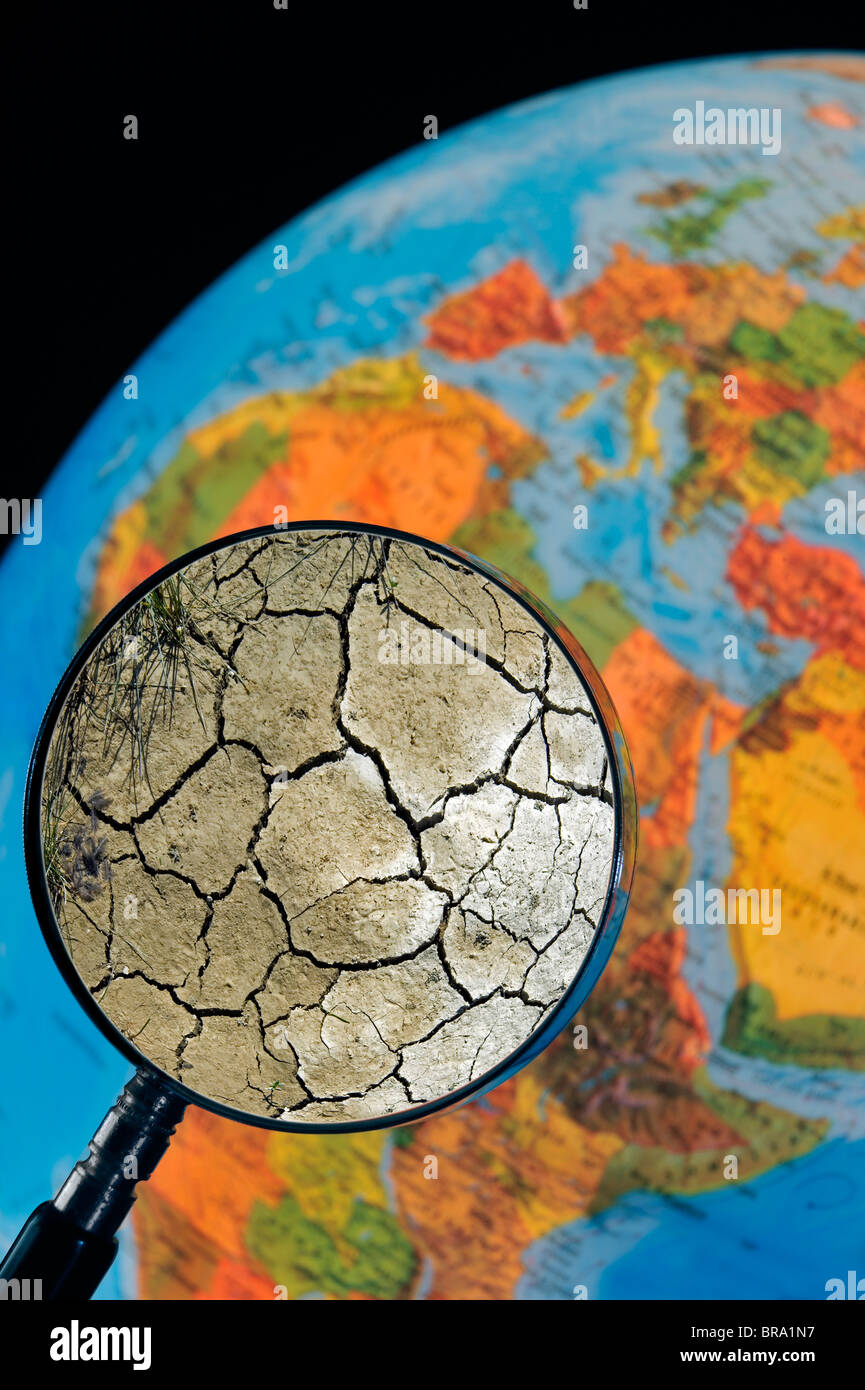 Erde von Dürre gesehen durch Lupe statt gegen beleuchtete Erdkugel geknackt Stockfoto