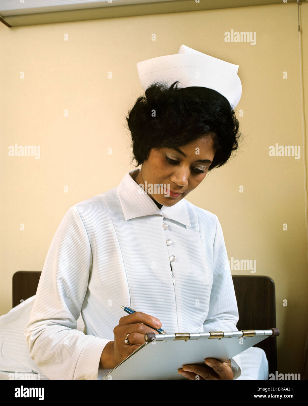 1970 1970S RETRO-AFRIKANISCHE AMERIKANISCHE SCHWARZE KRANKENSCHWESTER DIAGRAMM UNIFORM Stockfoto