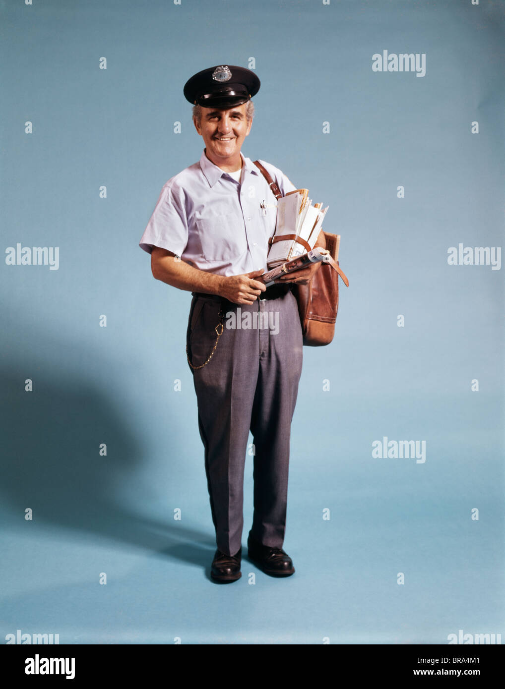1970ER JAHREN STÄNDIGEN FULL LENGTH PORTRAIT OF MITTE IM ALTER VON MAILMAN MAIL TRAGETASCHE IN UNIFORM Stockfoto