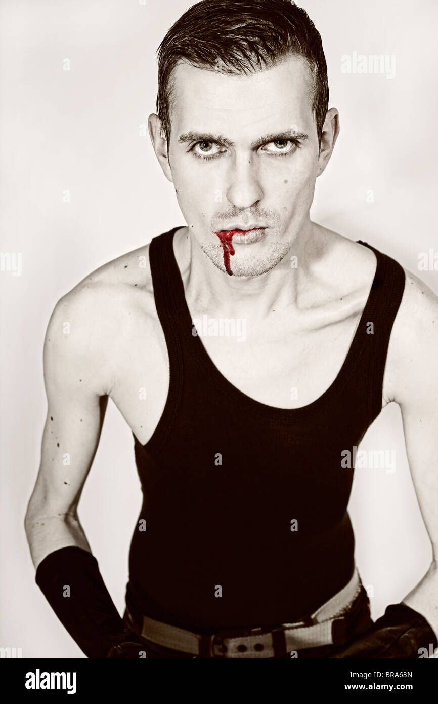 monochrome Portrait von einem jungen Mann mit Blut an seinen Lippen Stockfoto
