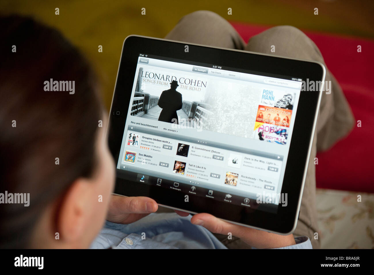 Frau mit iPad Tablet-Computer zu Hause zu iTunes digital Music Store durchsuchen Stockfoto