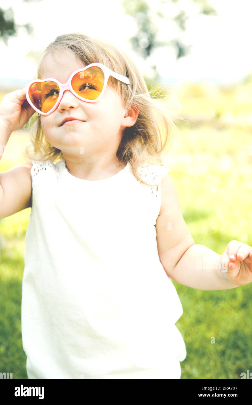 Junges Mädchen in herzförmige Sonnenbrille Stockfoto