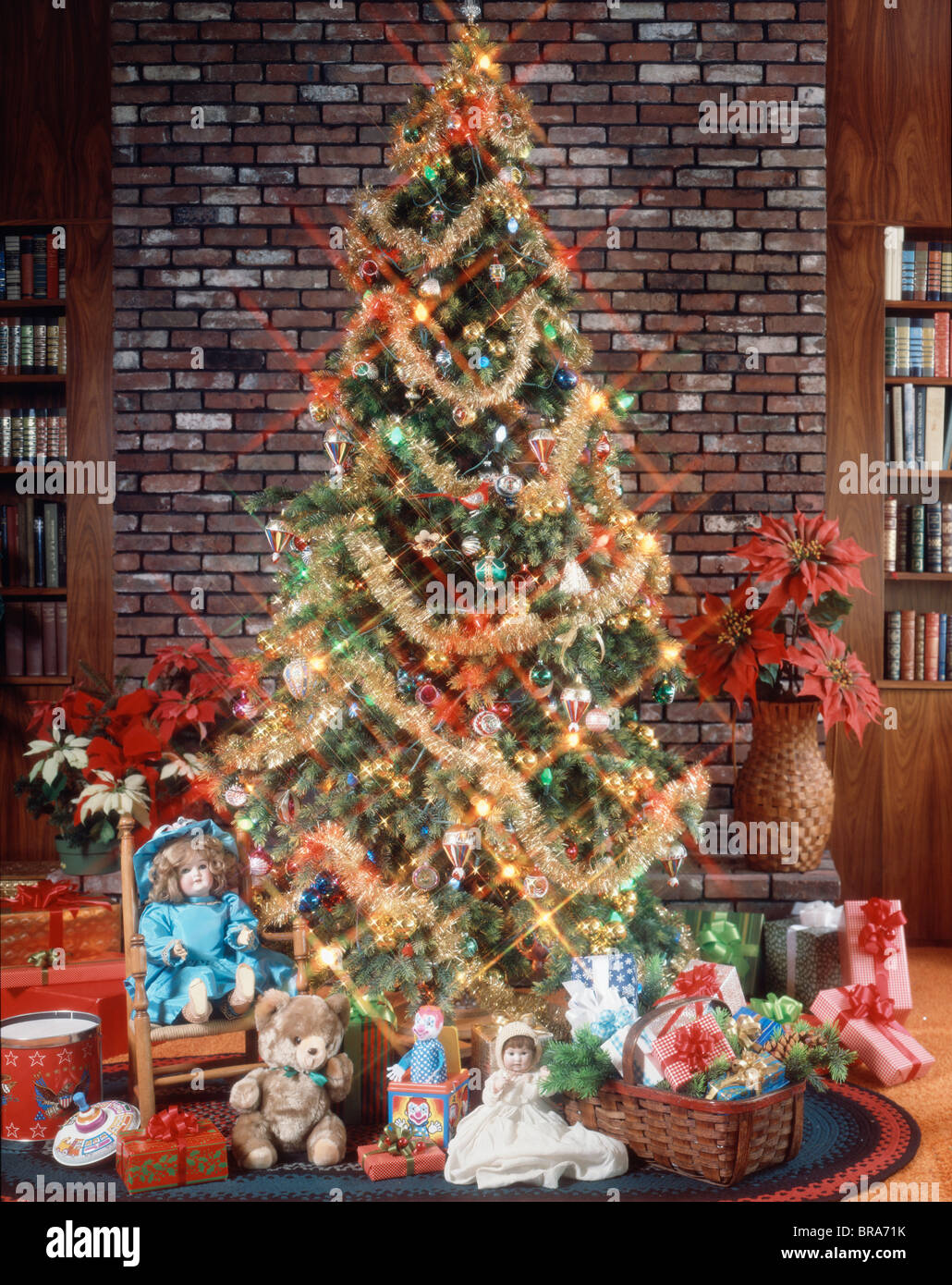 WEIHNACHTSBAUM MIT DEKORATION GIRLANDE LICHTERN, SPIELZEUG UND GESCHENKE UNTER DEM BAUM Stockfotografie