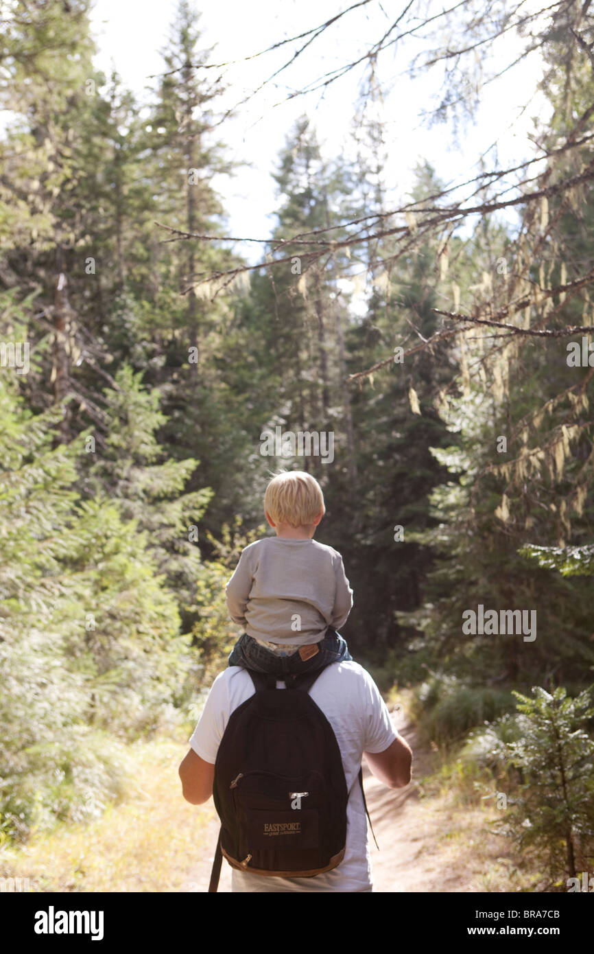 Junge auf den Schultern der Väter im Wald Stockfoto