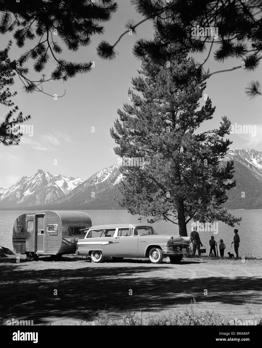1950ER JAHRE FAMILIE KOMBI & TRAILER GEPARKTEN JACKSON SEE GRAND TETON BERGE IM HINTERGRUND Stockfoto