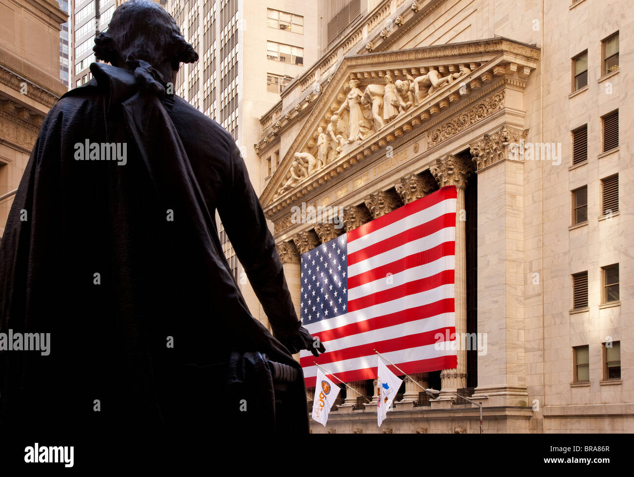 Riesige amerikanische Flagge auf dem Gebäude der New York Stock Exchange mit Statue von George Washington, New York City, USA Stockfoto