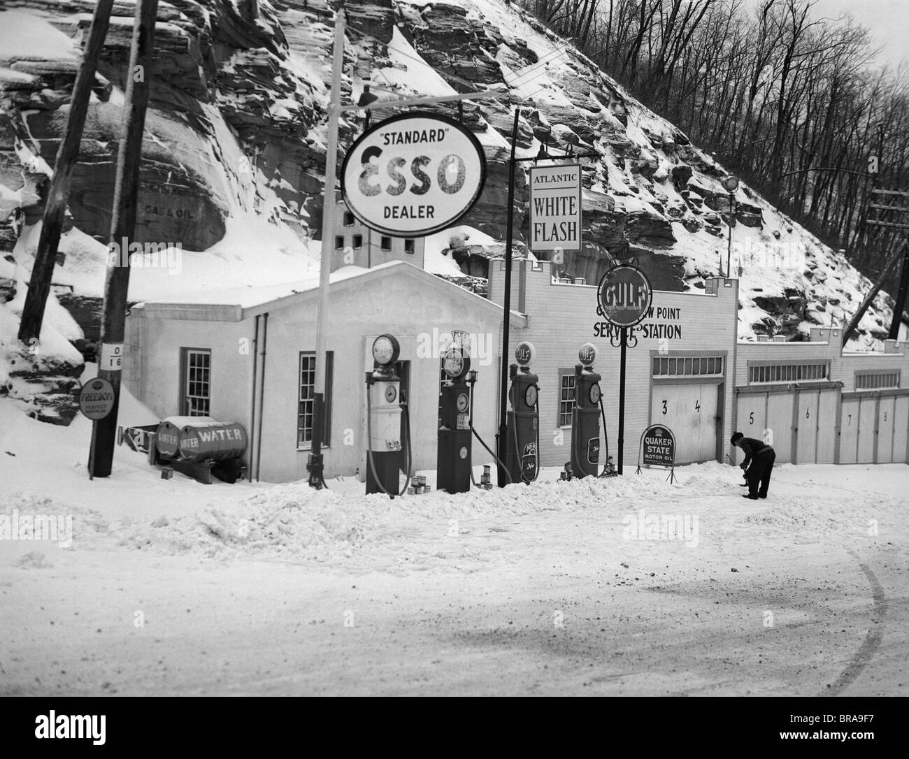 1940ER JAHRE TANKSTELLE IN BERGEN IM WINTER MEHRERE GAS PUMPEN GARAGEN & ÖL & GAS ZEICHEN Stockfoto