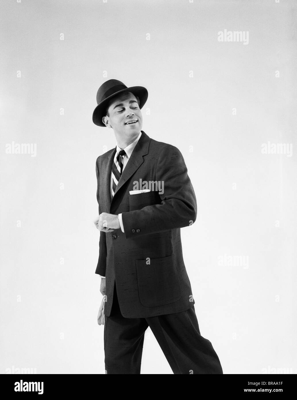 1950ER JAHRE MANN IN BUSINESS ANZUG HOLDING OUT UNTERARM ALS WENN SICH EIN PARTNER ARM Stockfoto