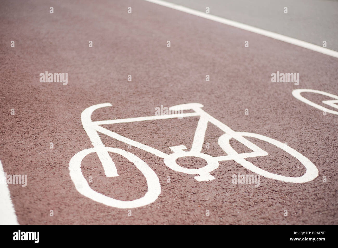 Ausgewiesenen Cycle Lane Symbol, gemalt auf einem roten Asphalt Fahrbahn, Brighton, Sussex, England Stockfoto