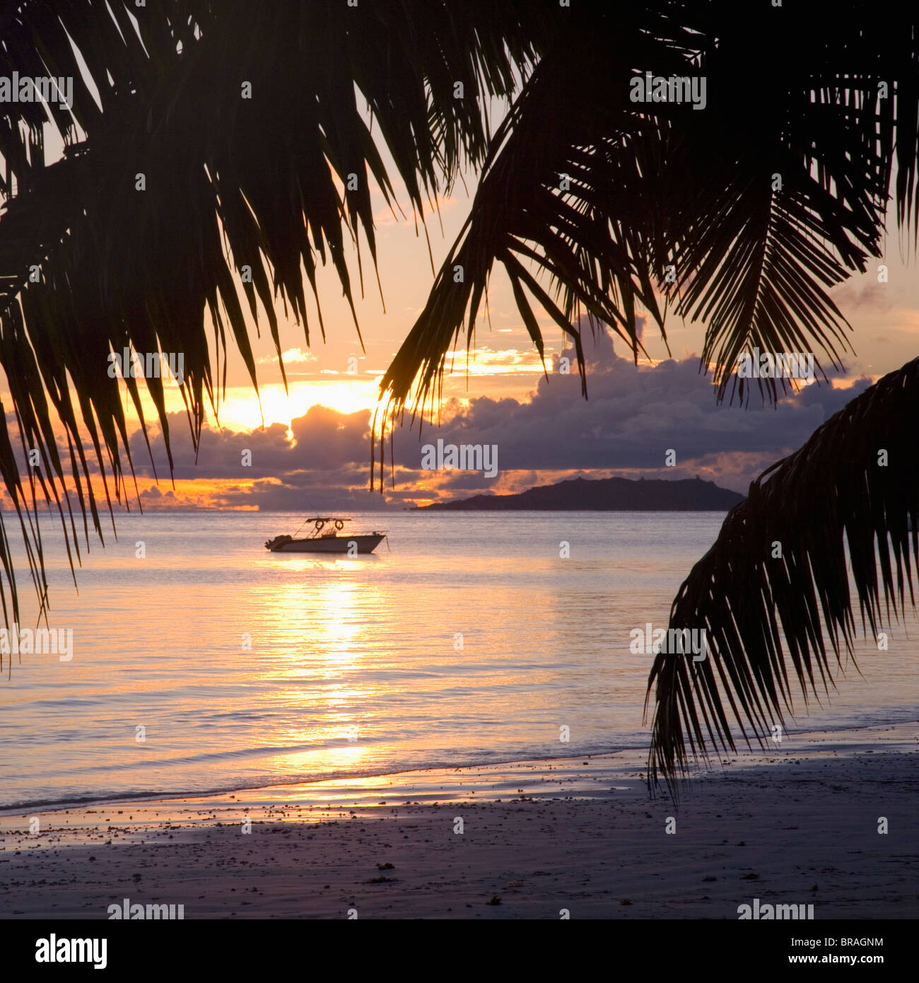 Kleines Boot vertäut am Strand am Anse Volbert bei Sonnenaufgang, Baie Sainte Anne Bezirk, Insel Praslin, Seychellen Stockfoto