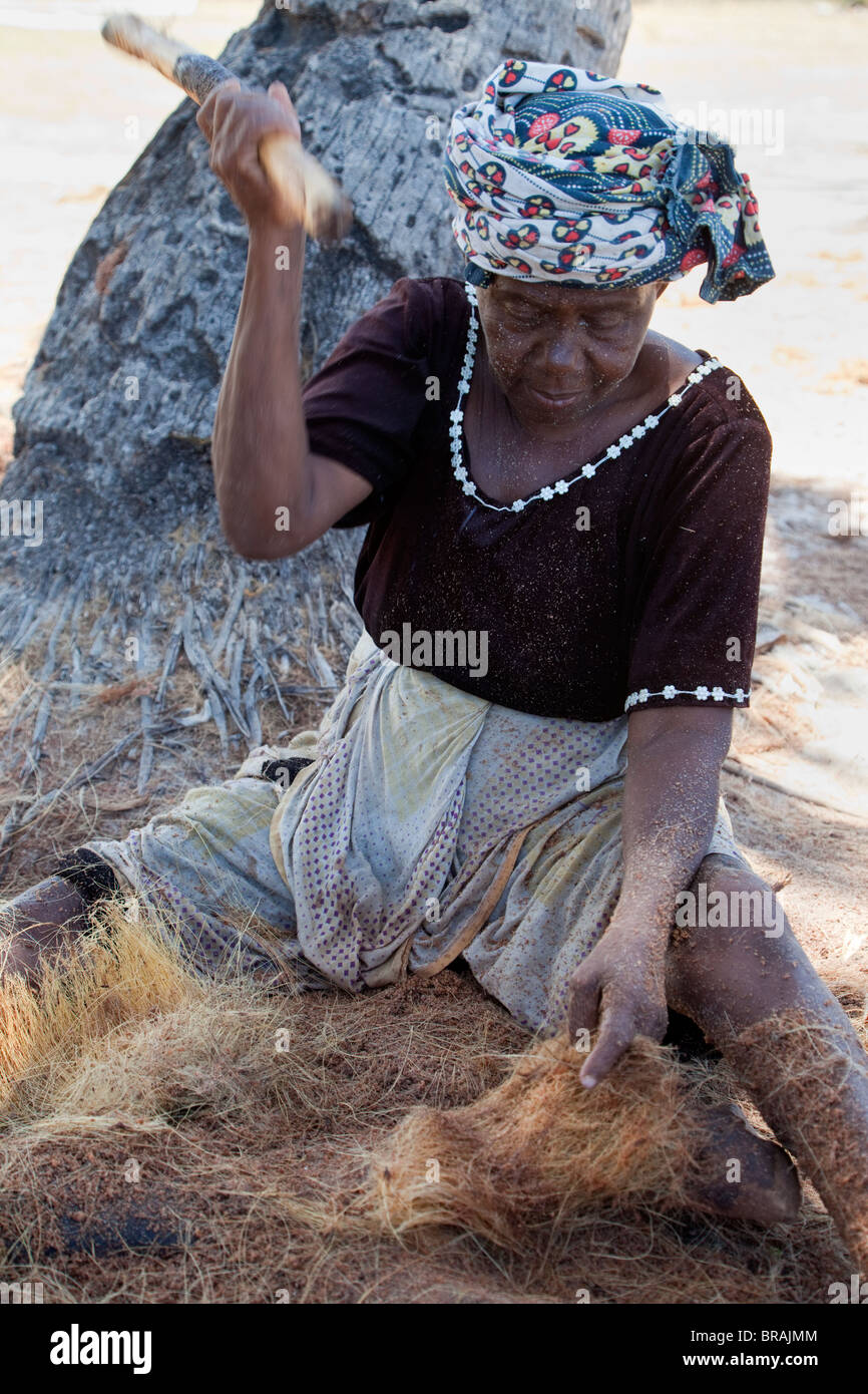 Kizimkazi, Dimbani, Sansibar, Tansania. Frau gegen Kokosnussschalen, Kokos, um Seile zu produzieren. Stockfoto
