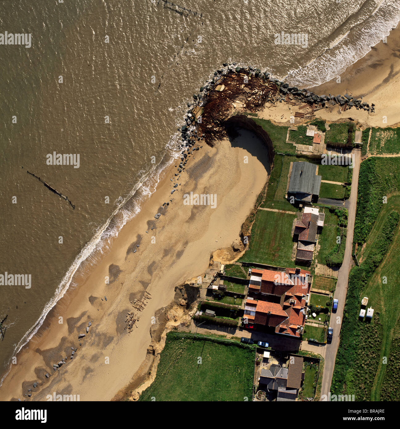 Luftaufnahme des Happisburgh, prekäre Lage von mehreren Häusern als Klippen von Küstenerosion, Norfolk, Großbritannien untergraben werden angezeigt Stockfoto