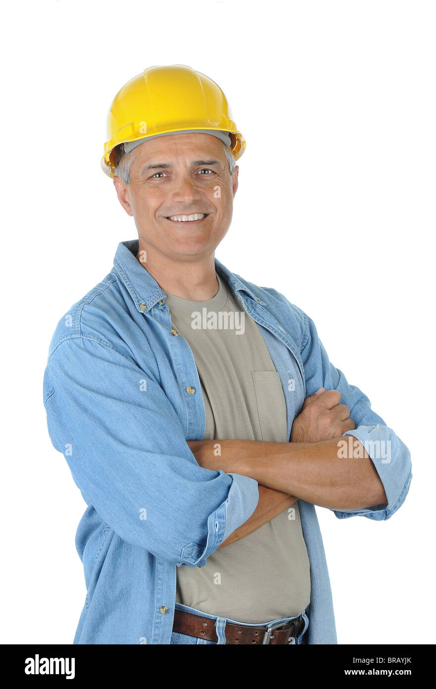 Arbeiter trägt einen gelben Schutzhelm und lächelt in die Kamera mit seinen Armen gekreuzt. Isoliert auf weiß in Hochformat. Stockfoto