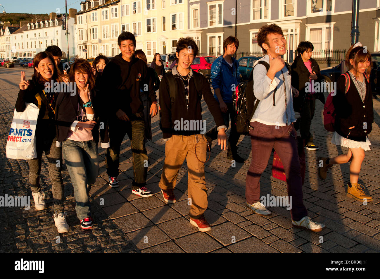 Eine Gruppe von glücklich lächelnde chinesische ausländischen Übersee Studenten an Aberystwyth Promenade, Wales UK Stockfoto