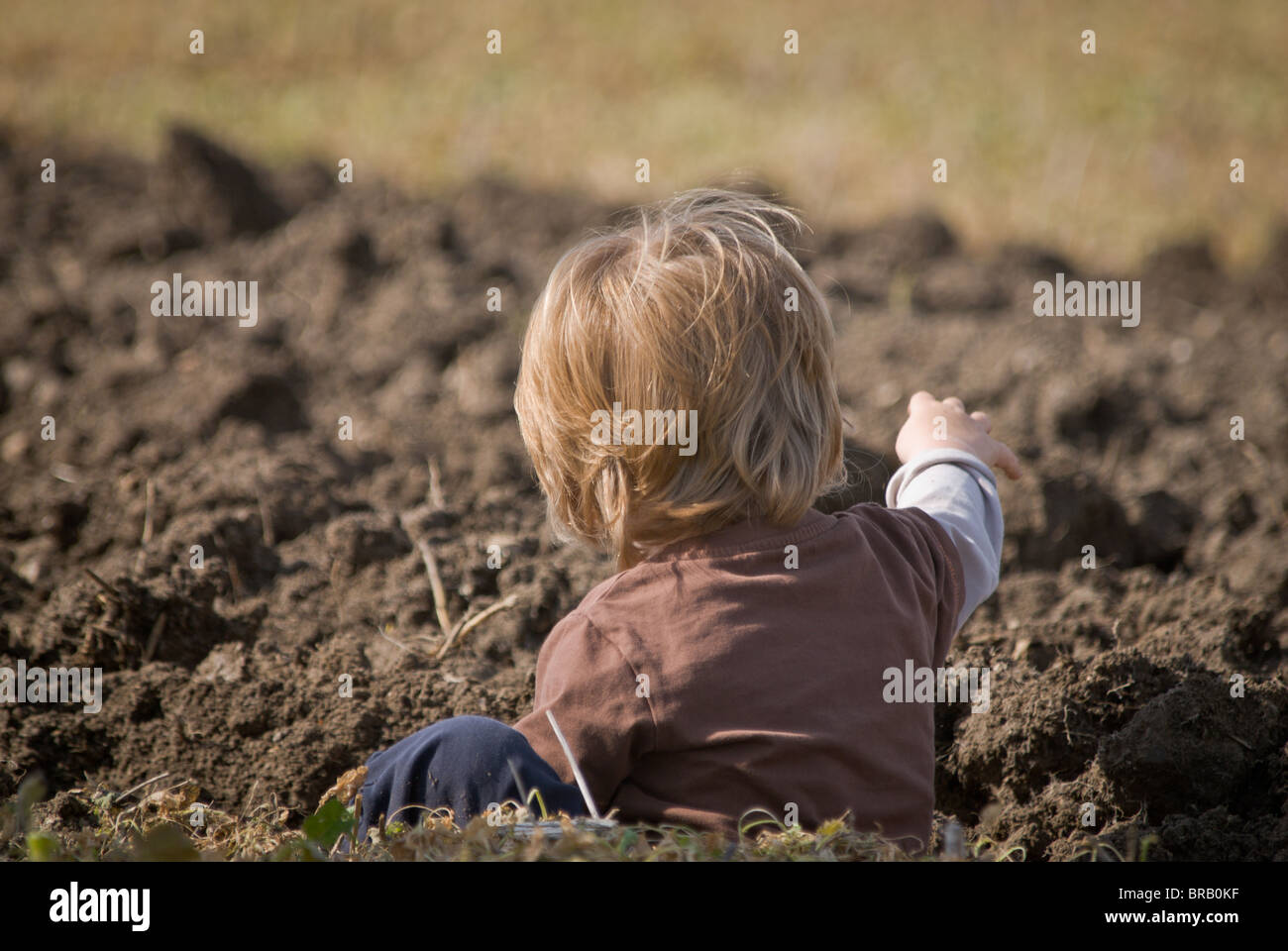 Kinder spielen im Schlamm Furche in eingereichten Stockfoto