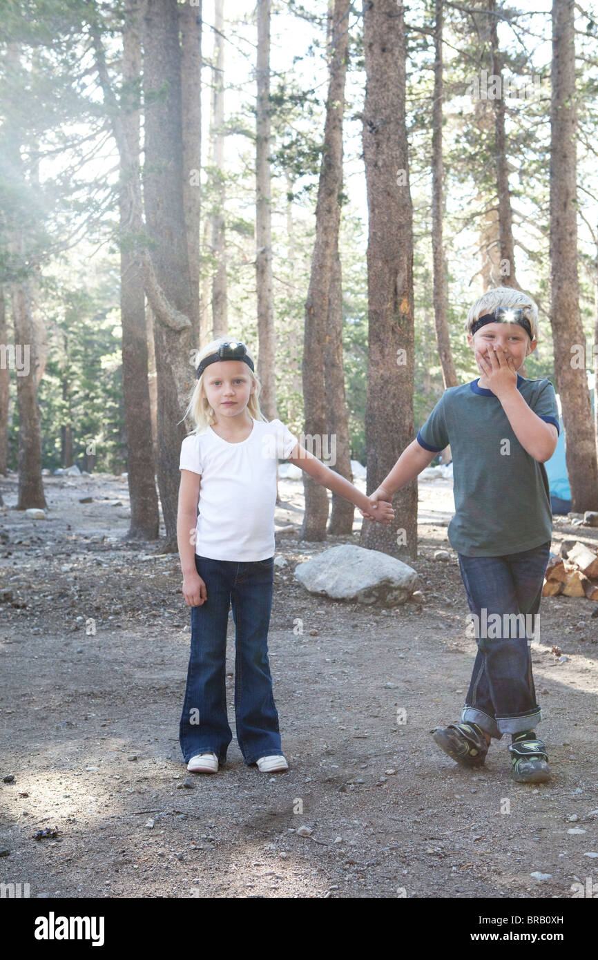 Jungen und Mädchen im Wald mit Scheinwerfer Stockfoto