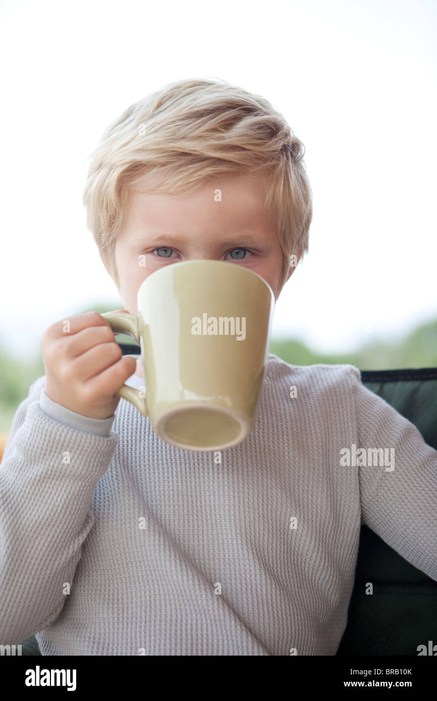 Kleiner Junge aus eine Kaffeetasse trinken Stockfoto