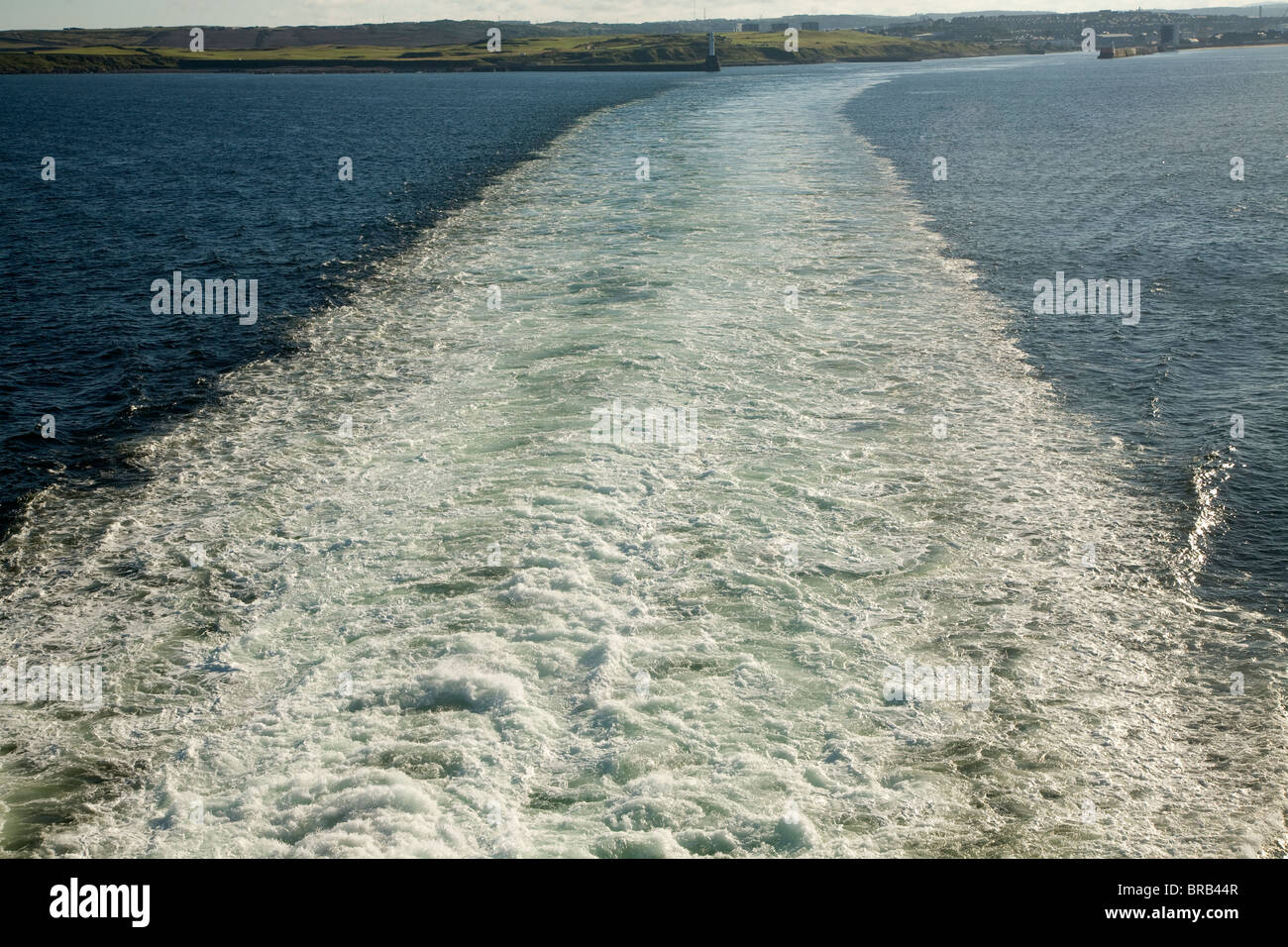 Großen Gefolge des Schiffes auf See in der Ferne Land hinterlassen Stockfoto
