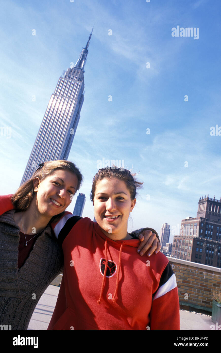 Zweibettzimmer junge Frauen posieren vor Empire State Building, NYC Stockfoto