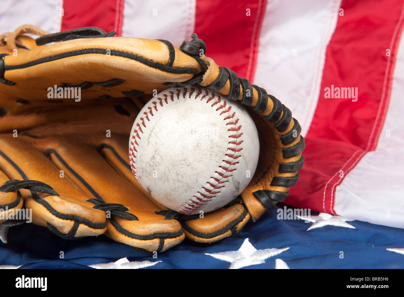 Ein Baseballhandschuh und Baseball auf eine amerikanische Flagge. Stockfoto