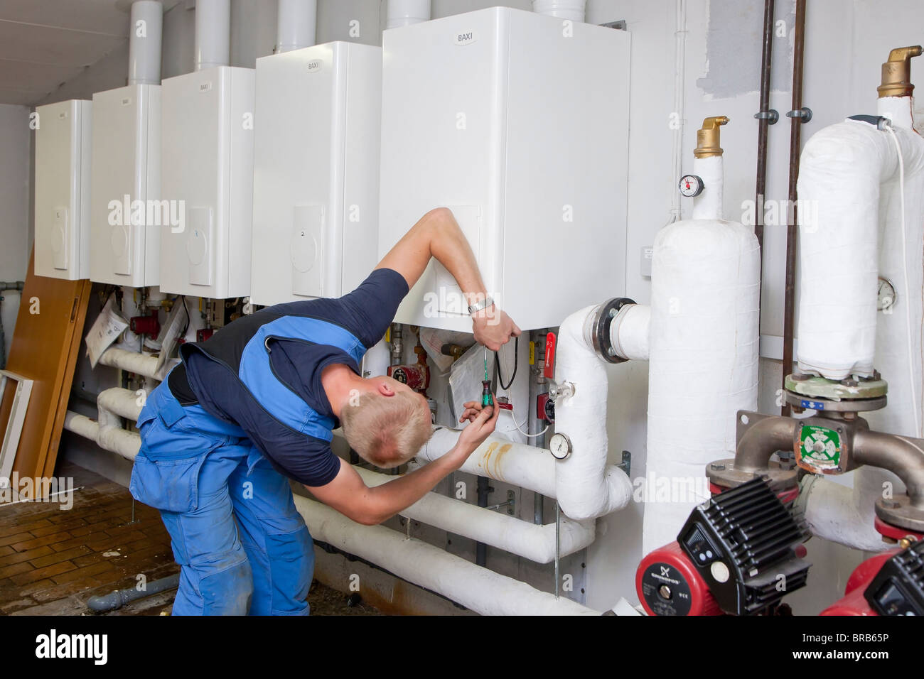 Heizungs- und Sanitär-Techniker testen und Anpassen einer Gasheizung Stockfoto