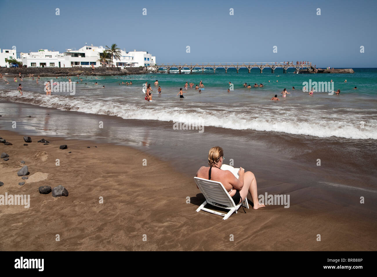 Sitzen in der Sonne warten auf die Flut am Strand von Playa Garita, Arrieta, Lanzarote Stockfoto