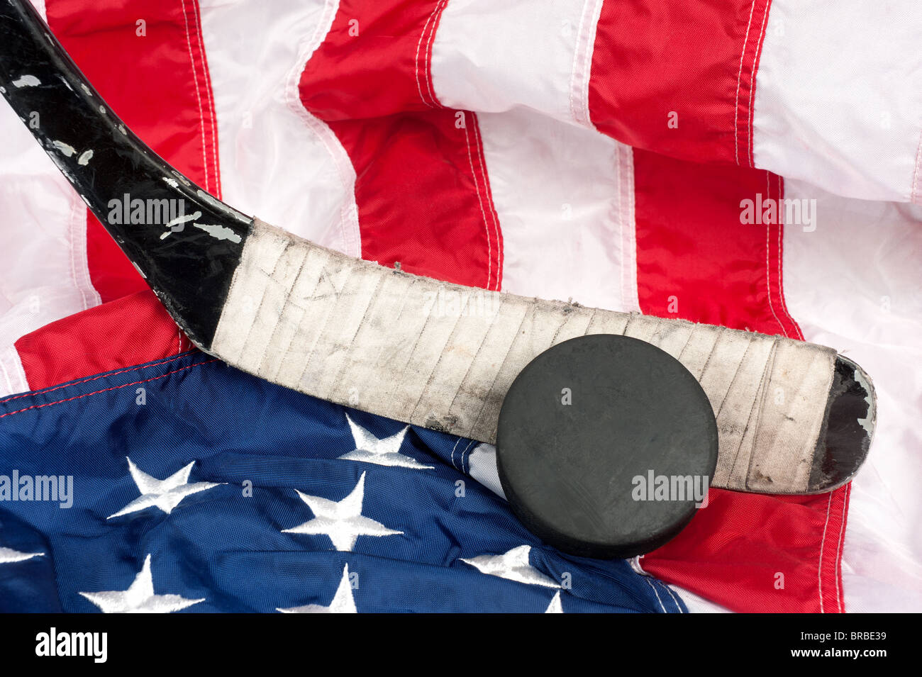Hockey-Ausrüstung, einschließlich einen Stock und Puck auf eine amerikanische Flagge, eine patriotische amerikanische Sportart abzuleiten. Stockfoto