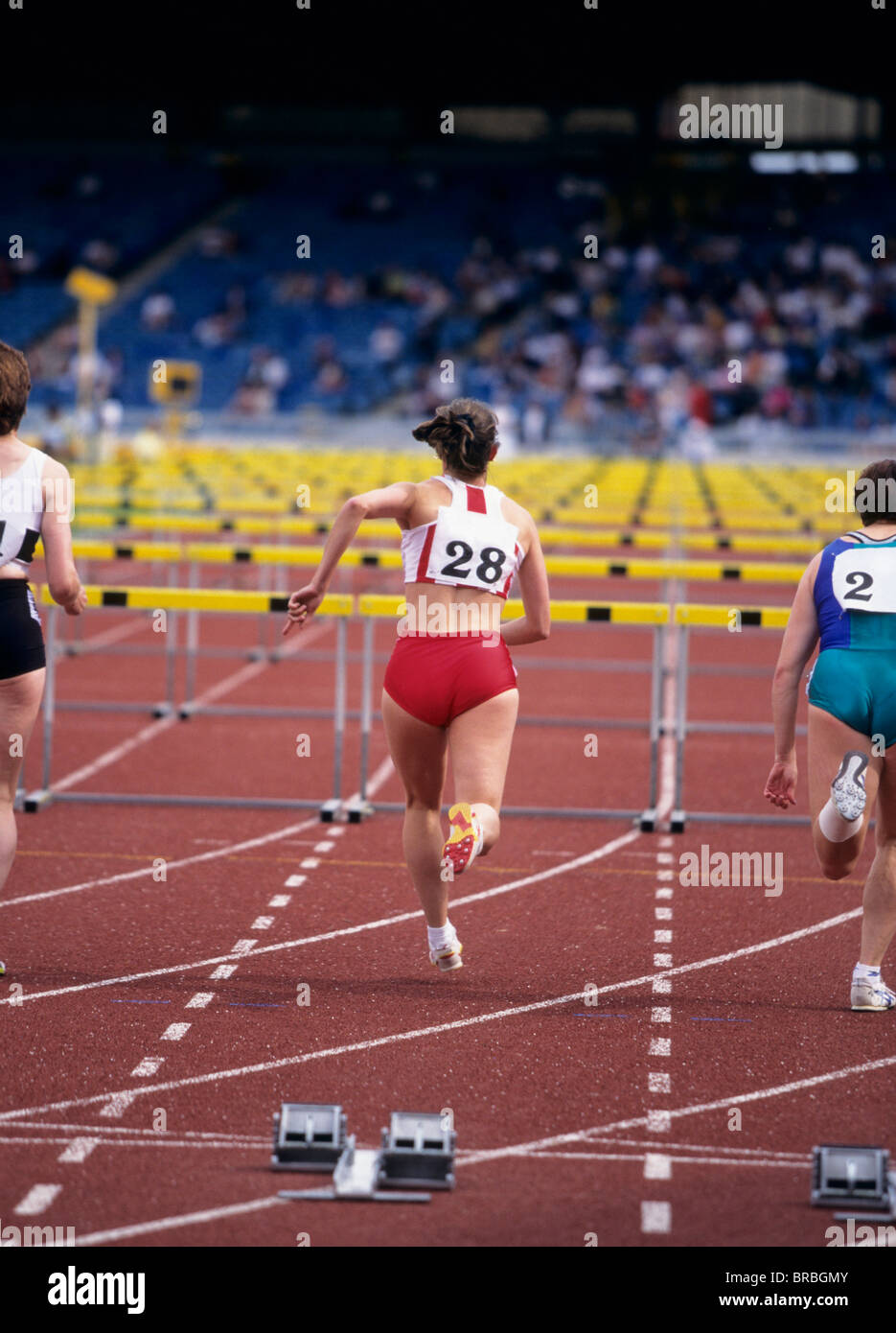 Drei weibliche Hürdenläufer zu Beginn des 100-Meter-Lauf Stockfoto