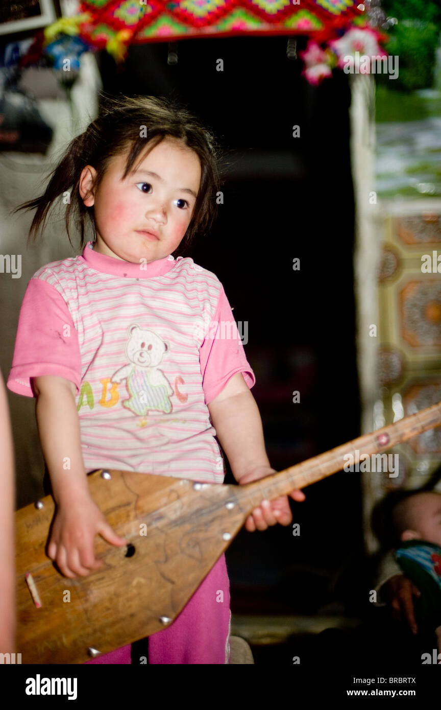 Ein junges Mädchen spielt die Dombura in Bayan Ölgii, Mongolei, Zentralasien Stockfoto