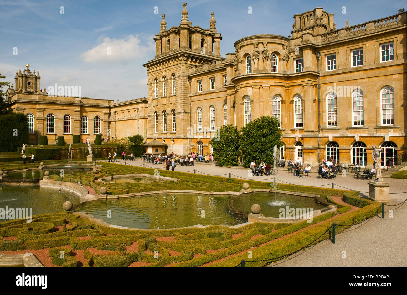 Touristen genießen die Sonne in den formalen Gärten im Blenheim Palace, Oxfordshire. Stockfoto