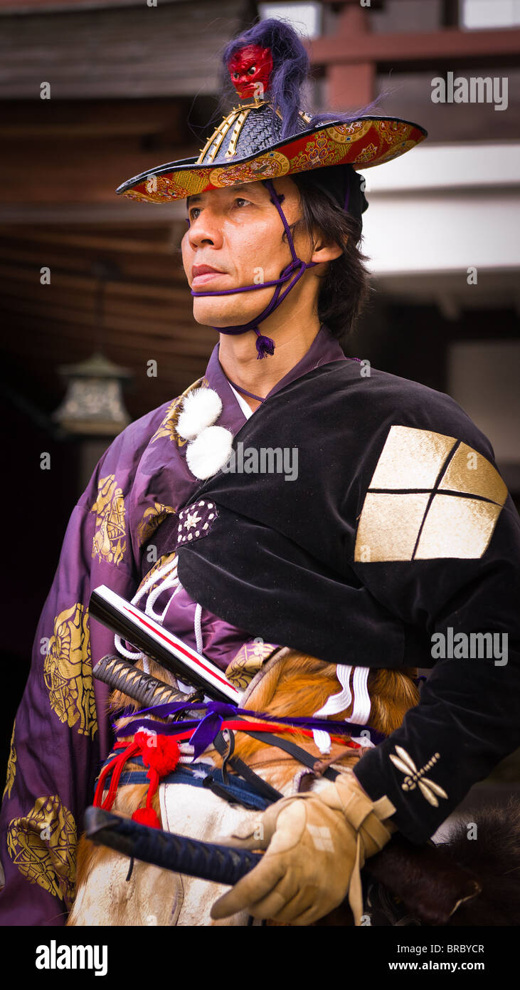 Ein Bogenschütze in alten Samurai Krieger einheitliche Posen vor dem Heiligtum Stockfoto