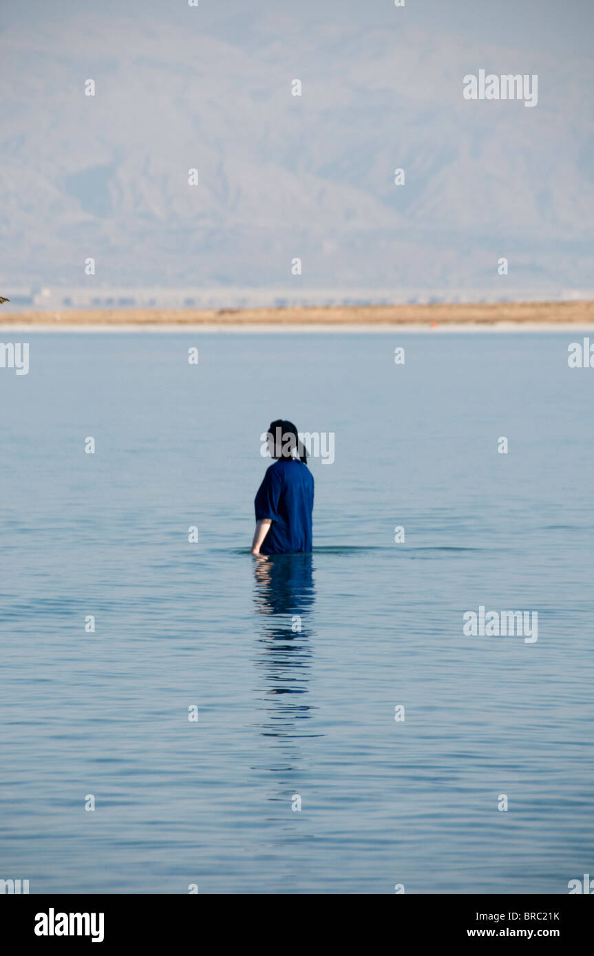 Rückansicht des religiösen jüdischen Frau voll bekleidet, Baden im Toten Meer Stockfoto