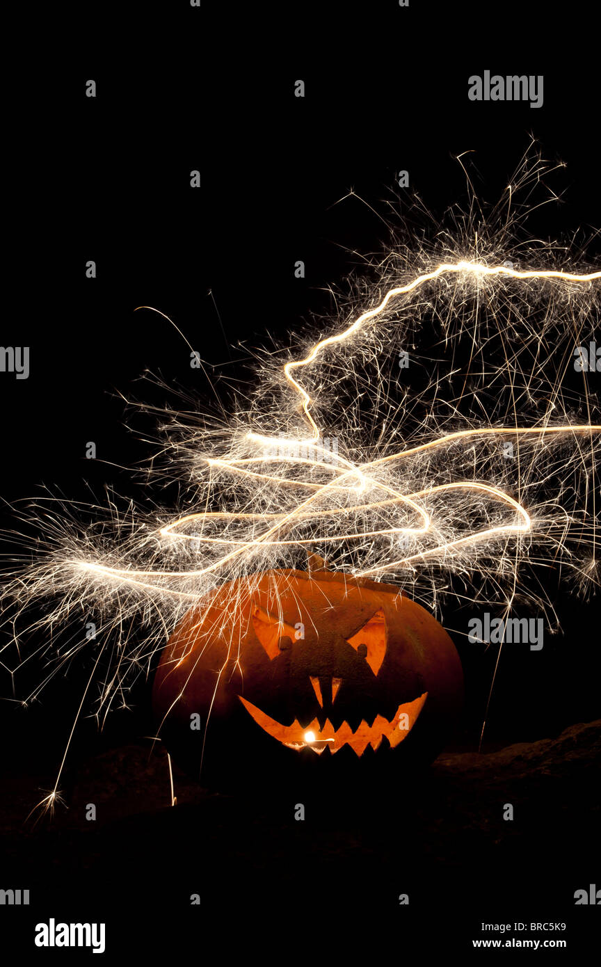 Halloween-Kürbis, Jack-o-Laterne, Feuer, Gesicht und Feuerwerk Stockfoto