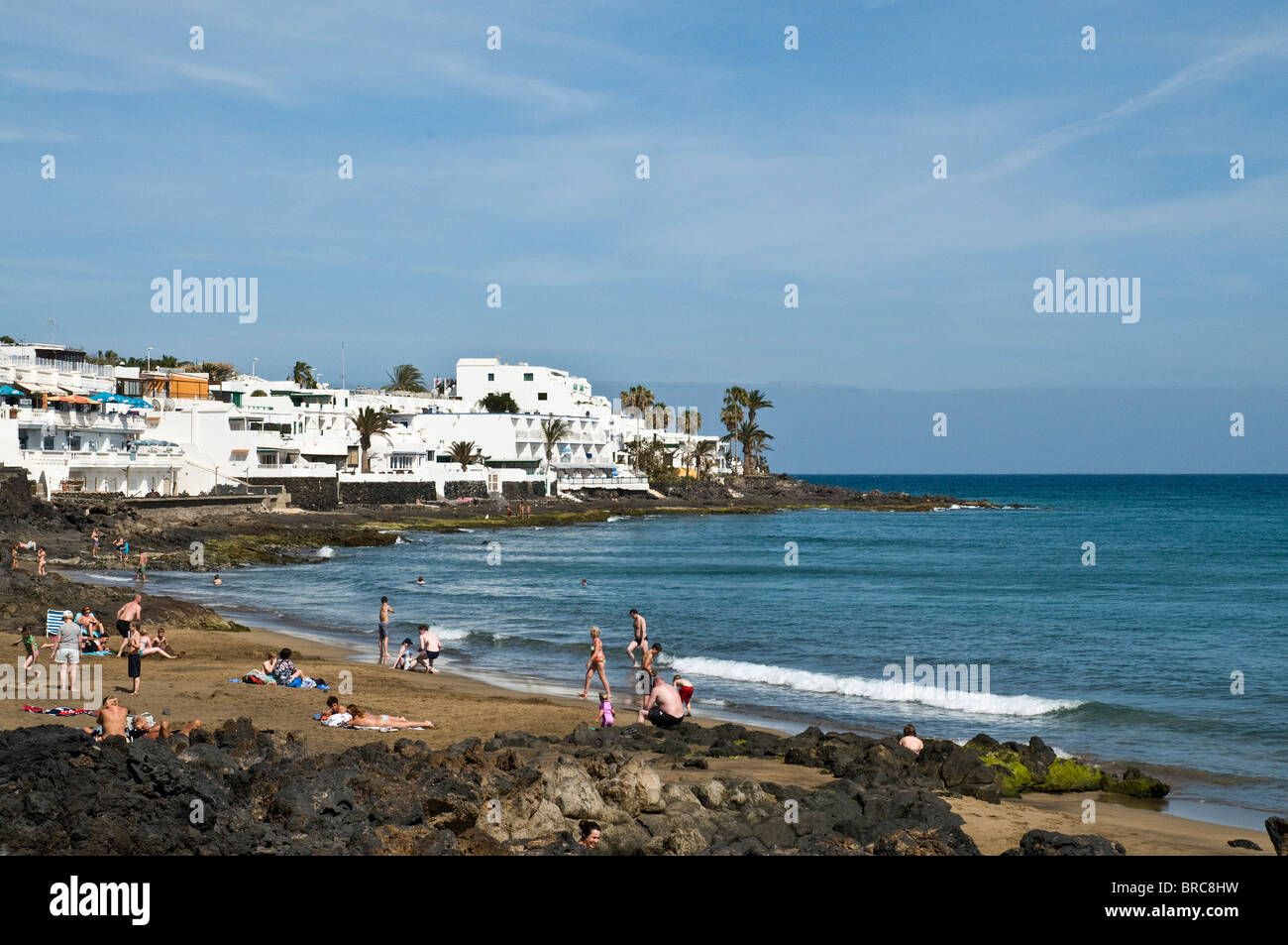 dh Strand PUERTO DEL CARMEN LANZAROTE Lavafelsen und schwarzen Sandstrand Meer weiße Haus Wohnungen Stockfoto