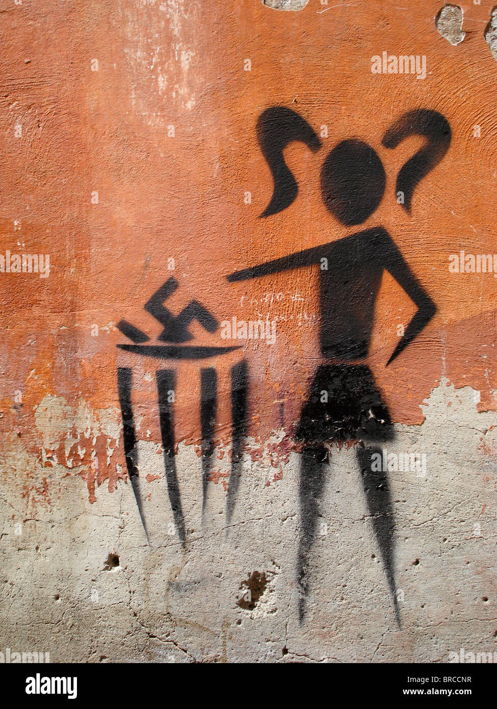 Anti-Nazi-Graffiti an der Wand in Rom, Italien - zeigt Bild Mädchen Hakenkreuz in einen Behälter zu werfen. Stockfoto