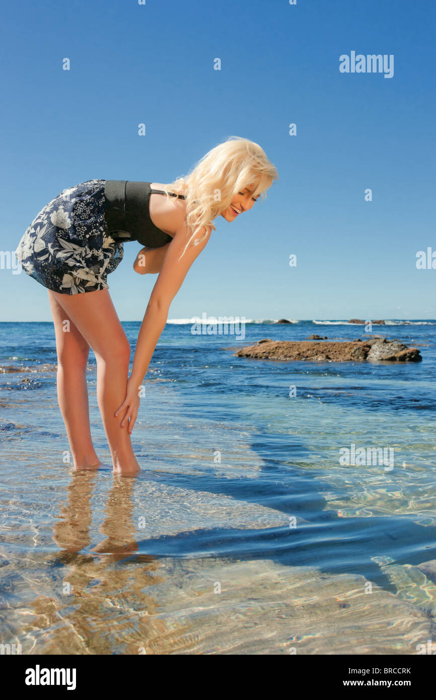 schöne junge Frau auf den Riff-Felsen am Meer Stockfoto