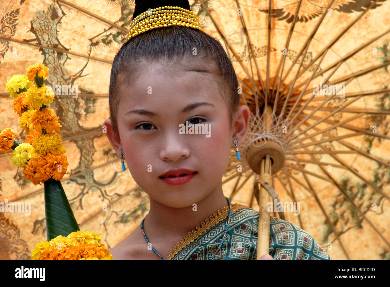 Ein junges Mädchen beteiligt sich an der jährlichen Lao Neujahr (Bun Pi Mai)-Parade durch Entspannung mit ihrem Schirm in Luang Prabang, Laos. Stockfoto