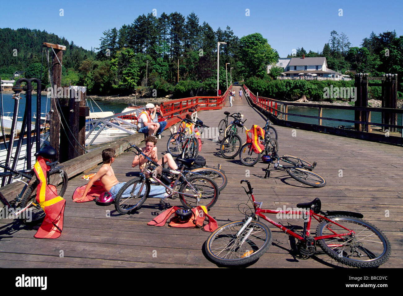 Mayne Island, südlichen Gulf Islands, BC, British Columbia, Kanada - Radfahrer ruht auf Dock Bergleute Bay, Sommer Stockfoto