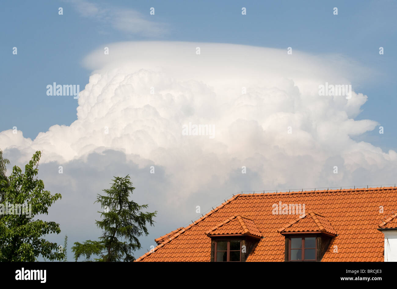 Cumulus-Wolken am blauen Himmel und Dach Stockfoto