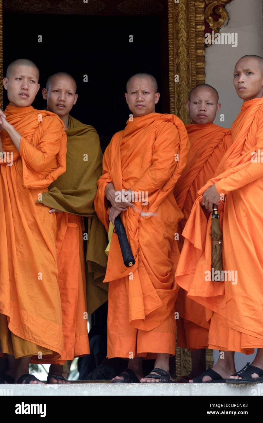 Buddhistische Mönche stehen auf der Veranda bei ihren Tempel vor der Jahresfeier Lao Neujahr und Parade in Luang Prabang, Laos Stockfoto