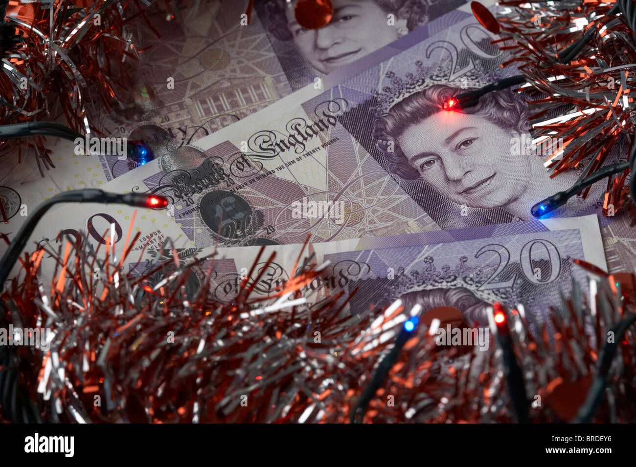 Haufen von zwanzig Pfund Sterling Banknoten mit Lametta Weihnachtsdekoration und Lichter Stockfoto