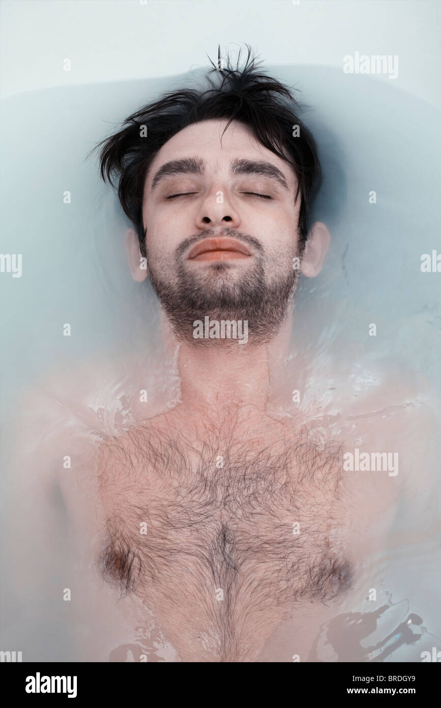 junger Mann in einem Badezimmer mit schlammigen Wasser Stockfoto