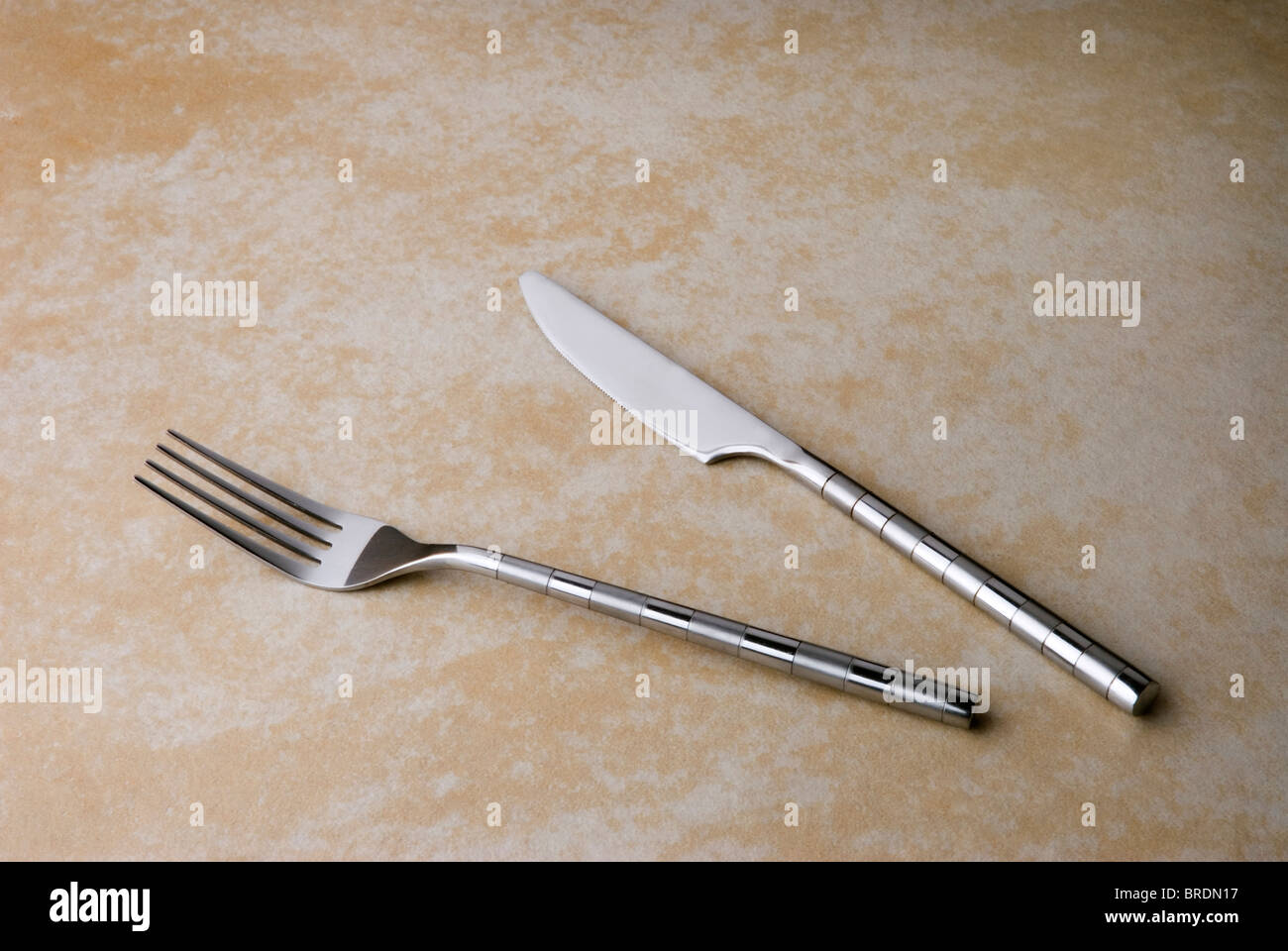 Messer und Gabel auf einem gefliesten Arbeitsplatte. Stockfoto