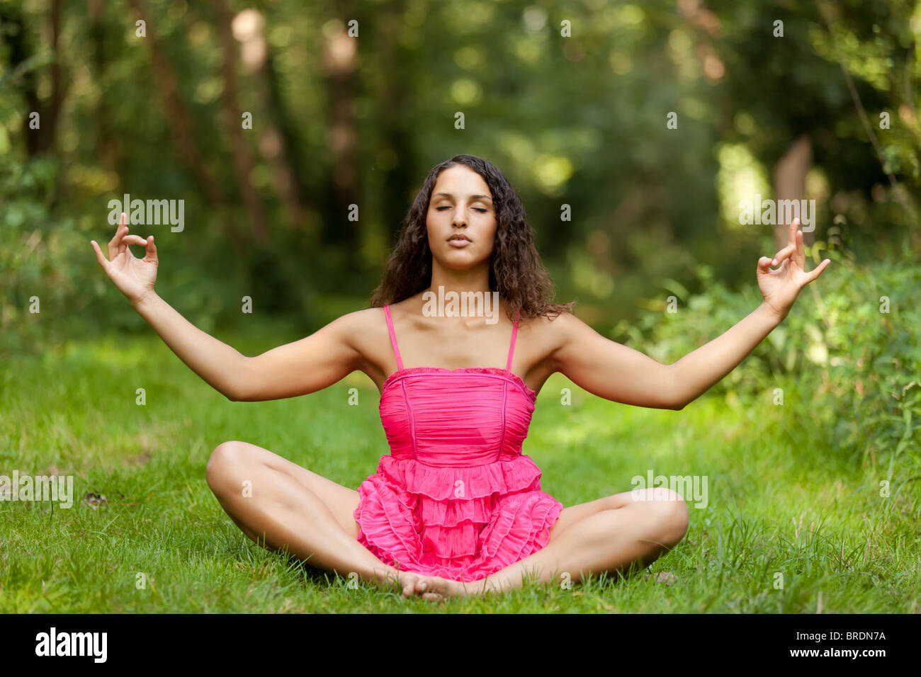 schöne junge Frau praktizieren Yoga in Wiese Stockfoto