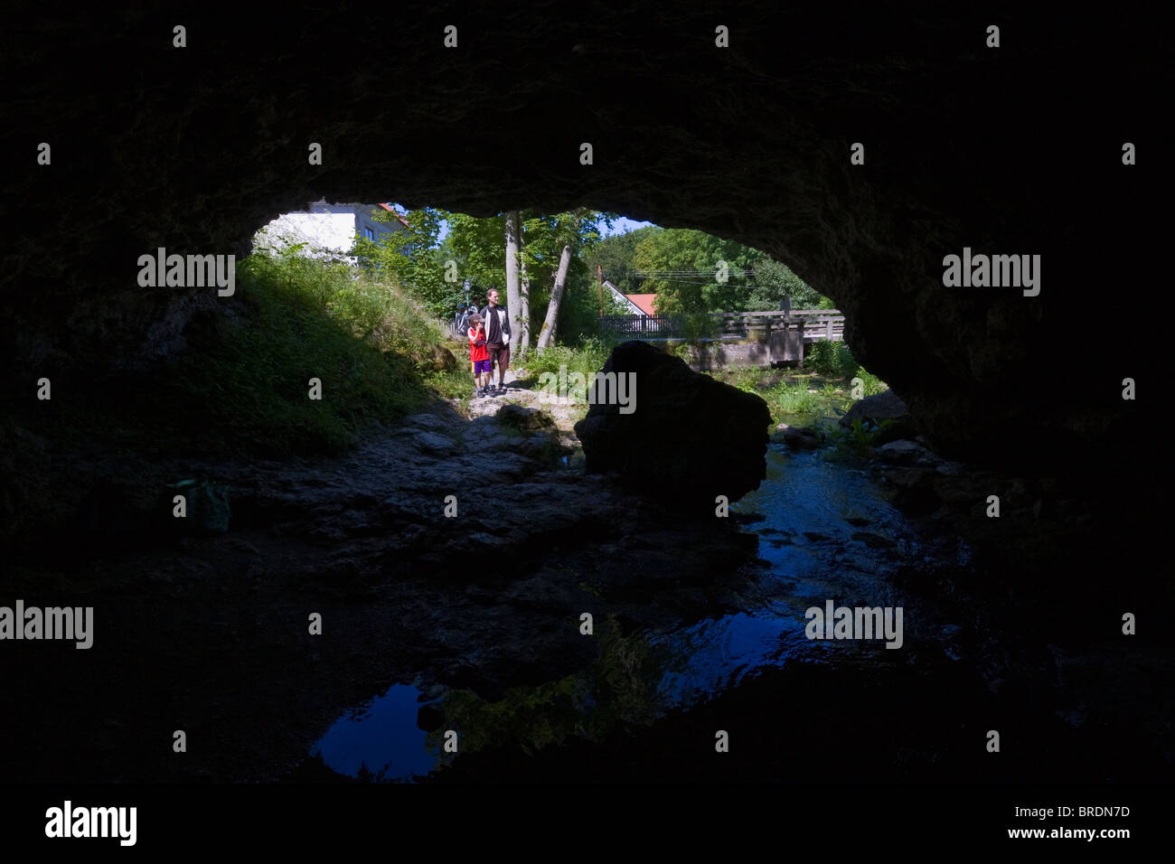 Ein paar Touristen in den natürlichen Eingang zu den Höhlen von Lummelunda, GOtland, Schweden Stockfoto