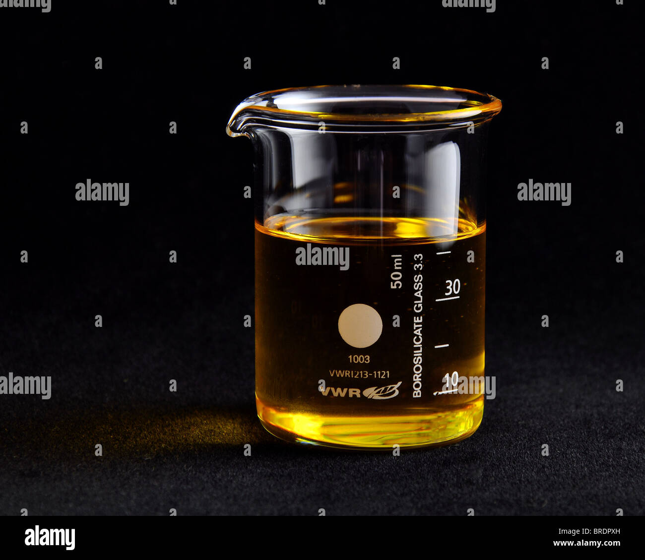 Farbloses Glas messen Becherglas 50ml Trägeröl auf einem schwarzen nahtlose Hintergrund enthält. weiche seitliche Beleuchtung Stockfoto