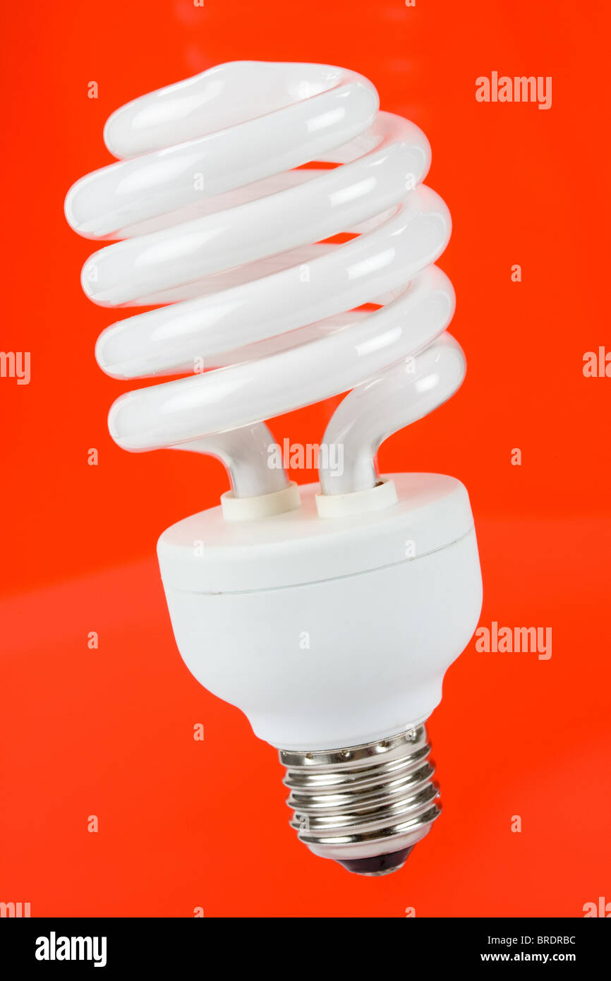 Compact Fluorescent Lightbulb mit rotem Hintergrund Stockfoto