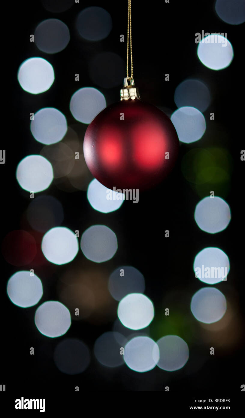 Rote Weihnachtskugel Dekoration. Unscharfe Lichter im Hintergrund. Stockfoto