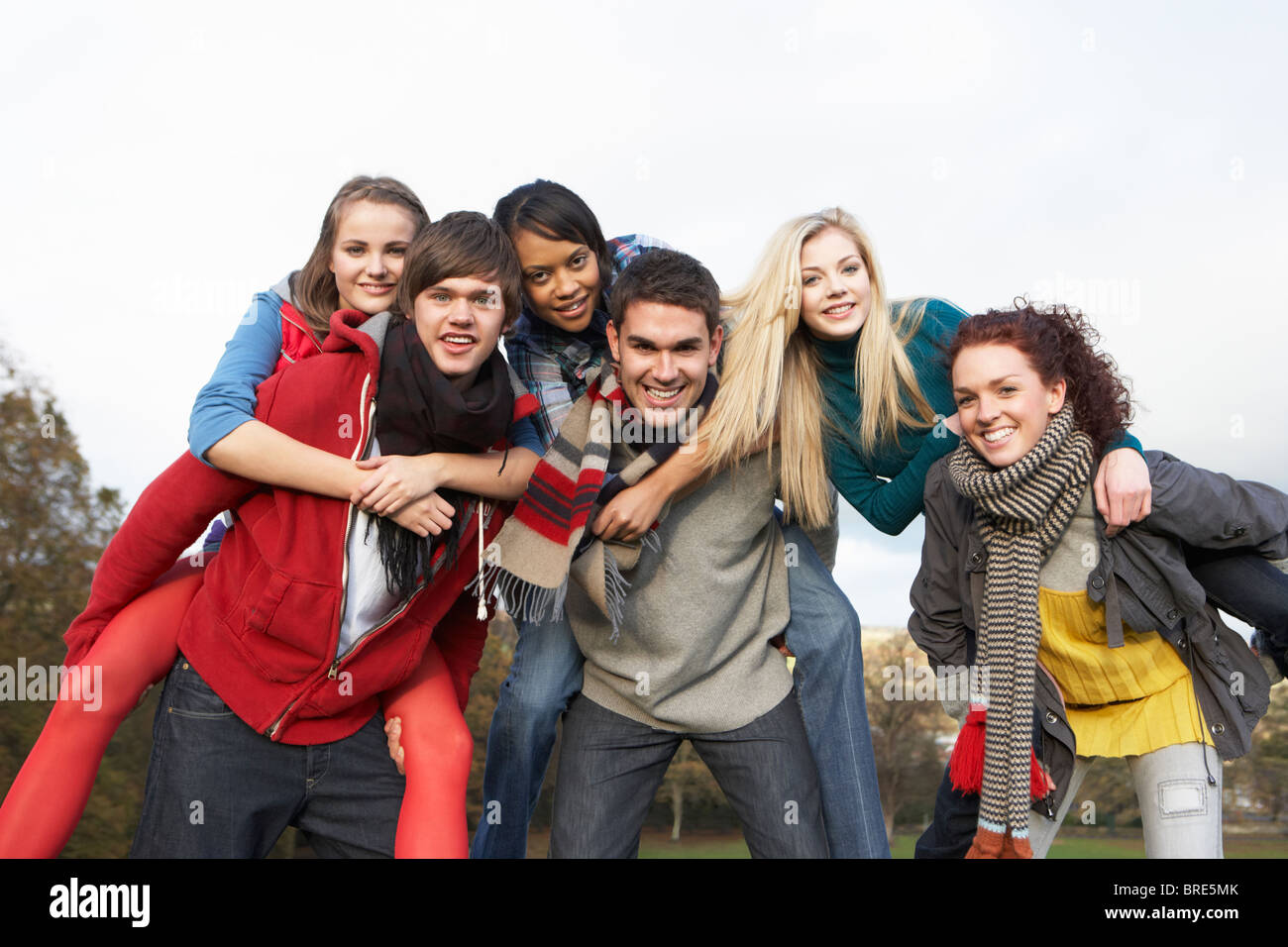 Freundeskreis Teenager mit Piggyback Fahrten im Herbst-Landschaft Stockfoto